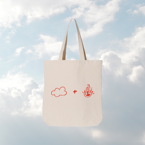 Tote bag with cloud and fire symbols against a cloudy sky background